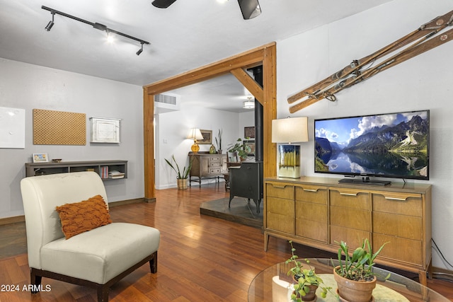 living room with dark hardwood / wood-style flooring and track lighting