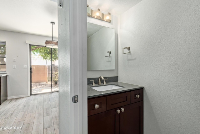 5704 E Aire Libre Ave Unit 1093, Scottsdale, AZ 85254 - bathroom with vanity, wood finished floors, and a textured wall