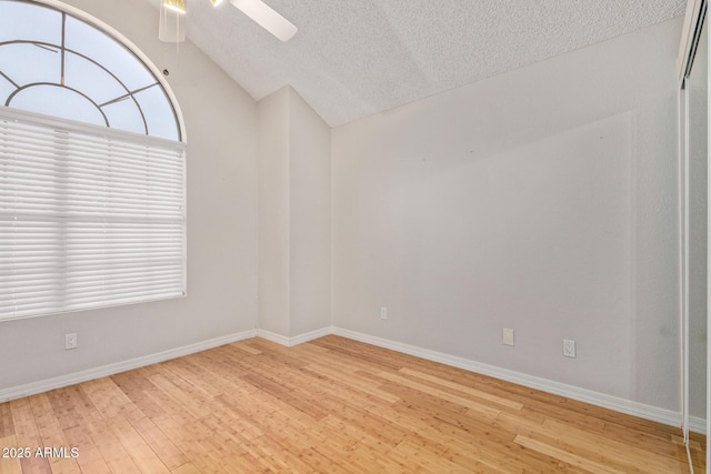 5704 E Aire Libre Ave Unit 1093, Scottsdale, AZ 85254 - spare room with light wood finished floors, a textured ceiling, a ceiling fan, and vaulted ceiling