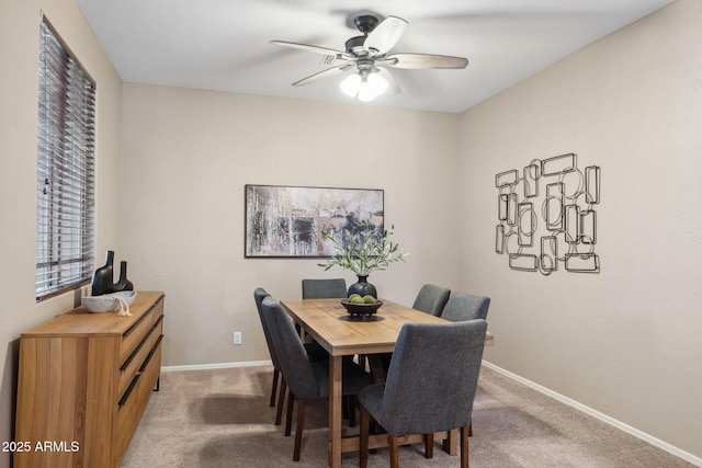 dining area with light colored carpet, baseboards, and ceiling fan