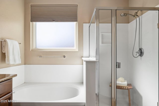 full bathroom with vanity, a garden tub, and a shower stall