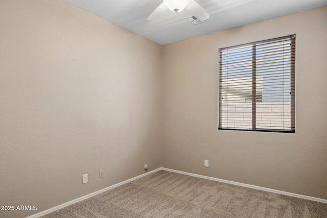 unfurnished room with a wealth of natural light, visible vents, ceiling fan, and carpet floors