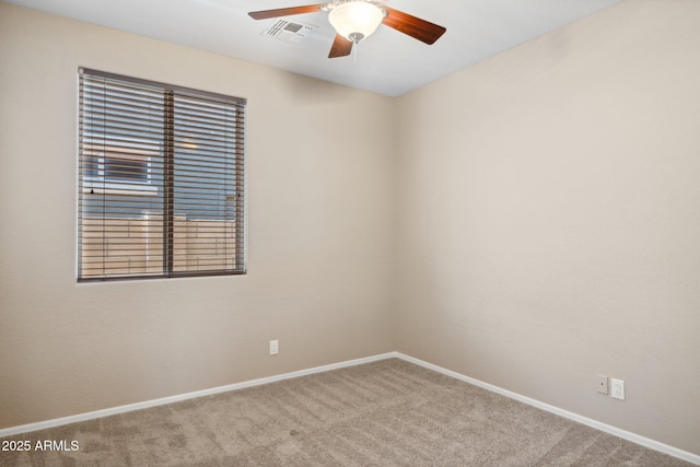 carpeted spare room featuring visible vents, baseboards, and a ceiling fan