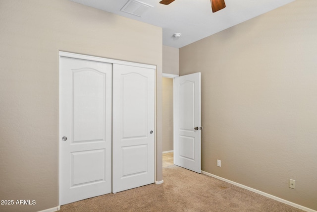 unfurnished bedroom with light colored carpet, visible vents, a closet, and baseboards