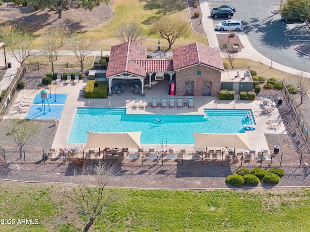 community pool with a patio and fence