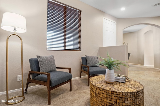 sitting room with arched walkways, visible vents, recessed lighting, and baseboards