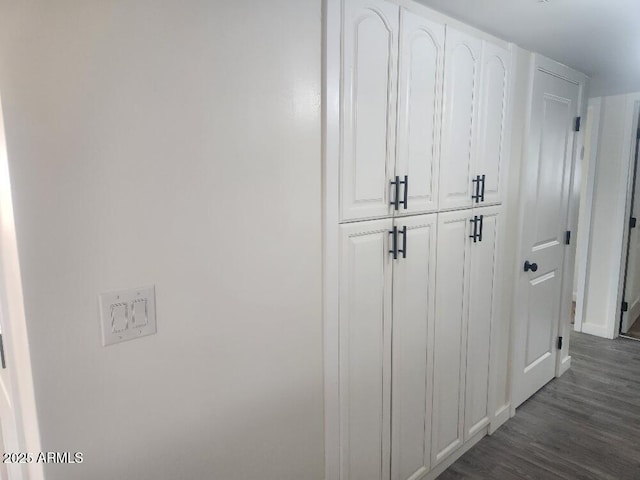 mudroom featuring dark wood-type flooring and baseboards