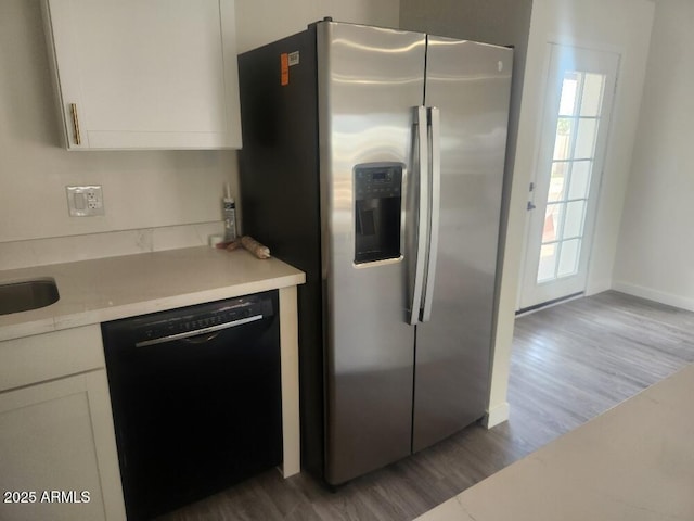 kitchen with dishwasher, stainless steel fridge, white cabinetry, and wood finished floors