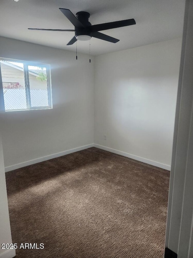 carpeted spare room with baseboards and a ceiling fan