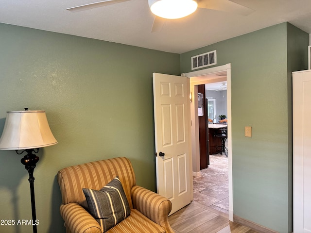 living area featuring ceiling fan and light hardwood / wood-style flooring