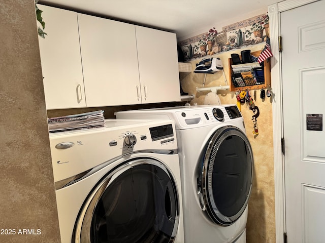 laundry room featuring washer and clothes dryer and cabinets