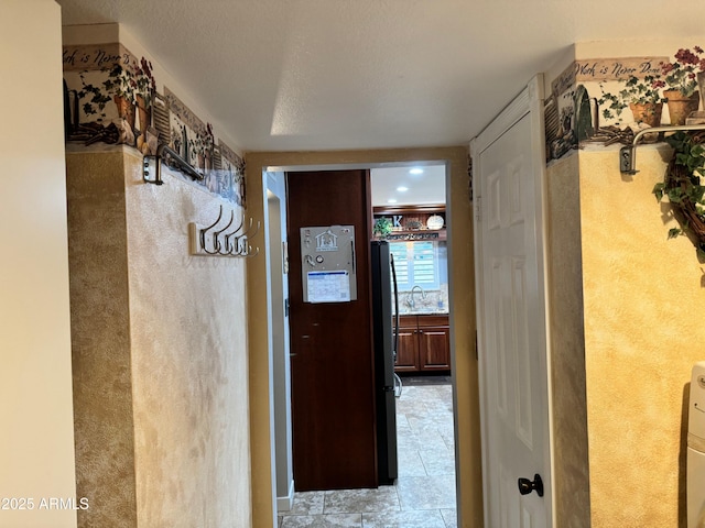 corridor featuring sink and a textured ceiling