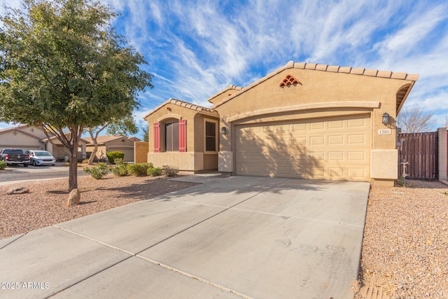 mediterranean / spanish-style home featuring driveway, an attached garage, a tile roof, and stucco siding