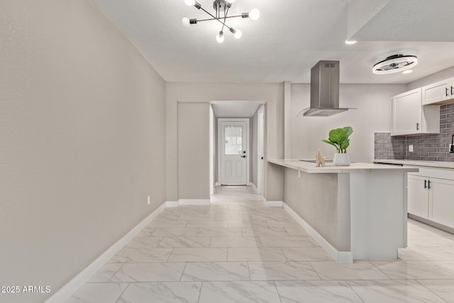 kitchen with a breakfast bar, white cabinetry, backsplash, island exhaust hood, and kitchen peninsula