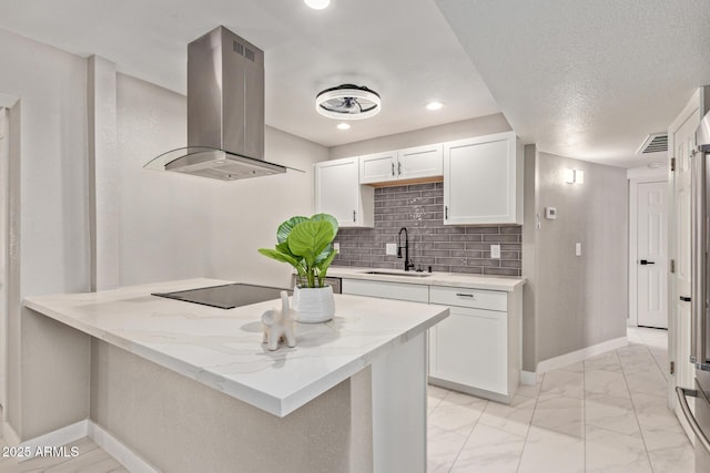 kitchen featuring sink, white cabinetry, island range hood, black electric cooktop, and light stone countertops