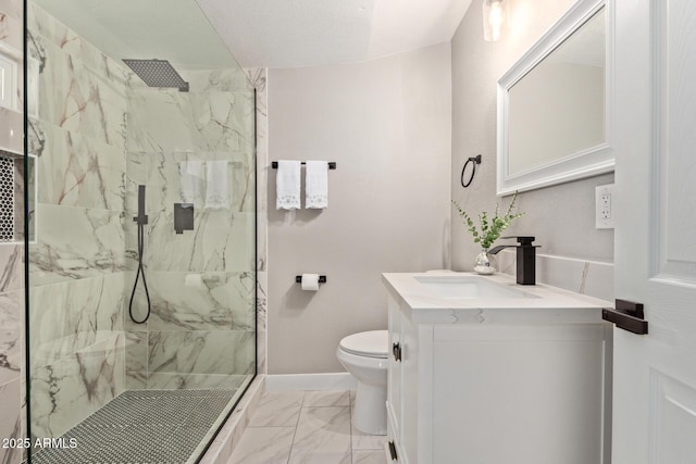 bathroom with vanity, tiled shower, and toilet