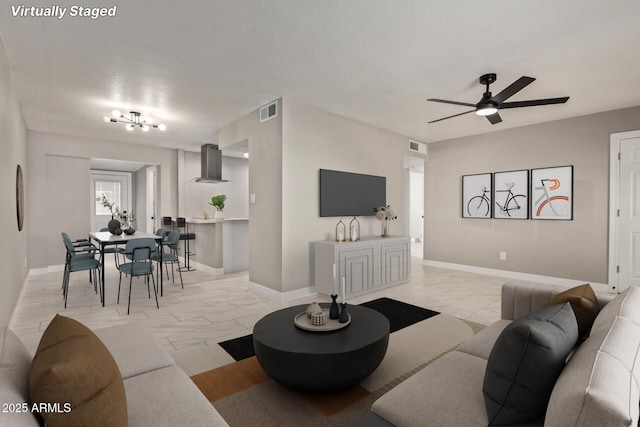 living room featuring a textured ceiling and ceiling fan