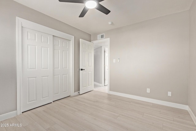 unfurnished bedroom featuring light hardwood / wood-style floors, a closet, and ceiling fan