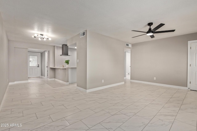 unfurnished living room with ceiling fan and a textured ceiling