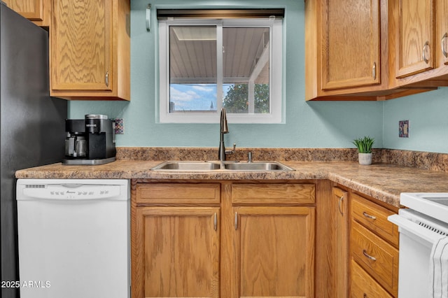 kitchen featuring dishwasher, light countertops, and a sink