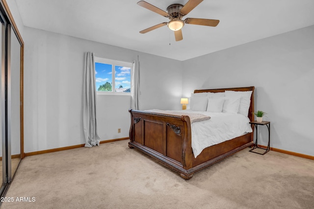 bedroom with a closet, light colored carpet, ceiling fan, and baseboards