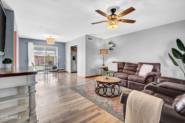 living area with light wood-style floors, baseboards, visible vents, and a ceiling fan