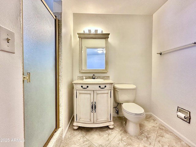 bathroom featuring a shower with door, vanity, and toilet