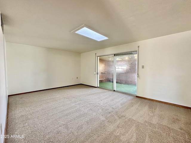 carpeted empty room with a skylight