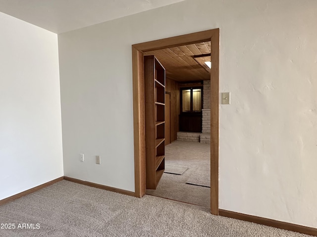 carpeted spare room featuring wood ceiling