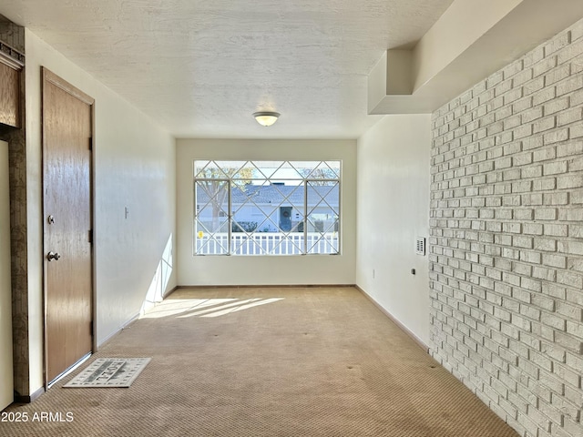 unfurnished room featuring a textured ceiling and light carpet