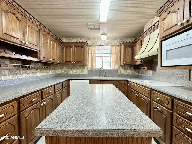 kitchen featuring sink, a kitchen island, extractor fan, and white appliances