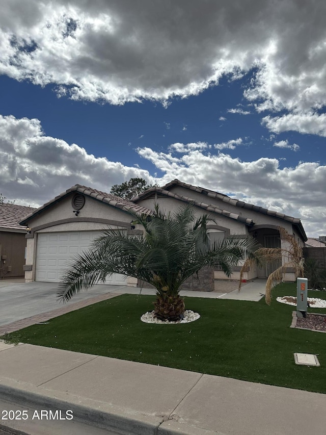 view of front of home featuring stucco siding, a front lawn, driveway, a garage, and a tiled roof