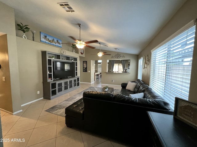 living area with visible vents, a ceiling fan, baseboards, light tile patterned floors, and lofted ceiling