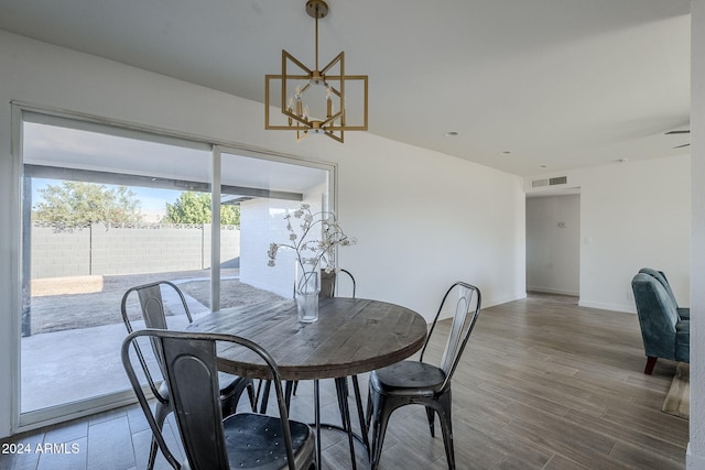 dining area with hardwood / wood-style floors and a chandelier