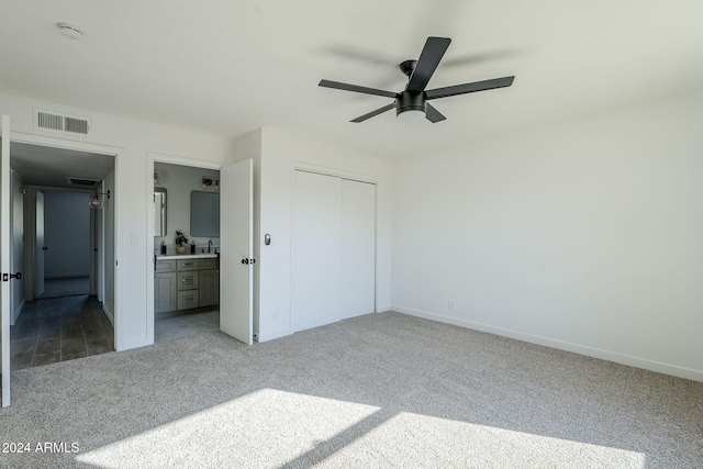 unfurnished bedroom featuring carpet flooring, connected bathroom, a closet, and ceiling fan