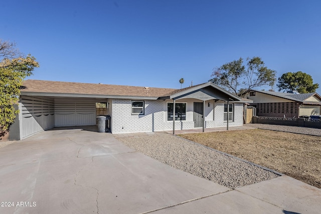 1436 E Downing St, Mesa, AZ 85203 - ranch-style home featuring concrete driveway, a carport, brick siding, and covered porch