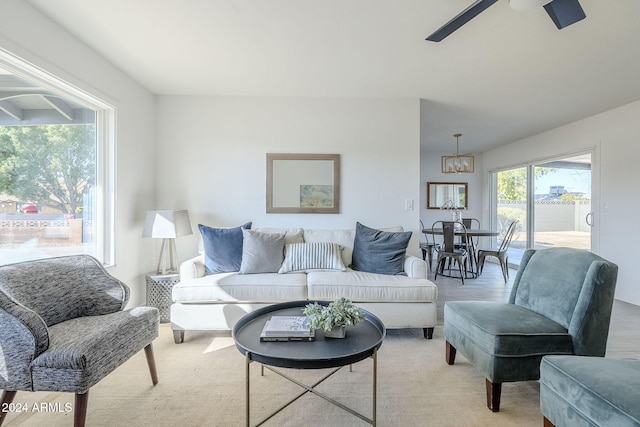 living room featuring ceiling fan with notable chandelier