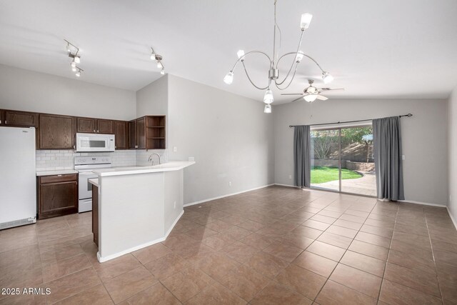 3713 W Nancy Ln, Phoenix, AZ 85041 - kitchen with white appliances, open shelves, open floor plan, vaulted ceiling, and light countertops