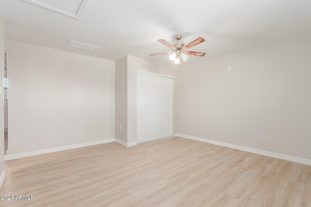 unfurnished bedroom with ceiling fan, a closet, and light hardwood / wood-style floors