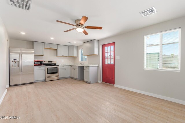 kitchen with stainless steel appliances, light hardwood / wood-style flooring, sink, ceiling fan, and gray cabinets