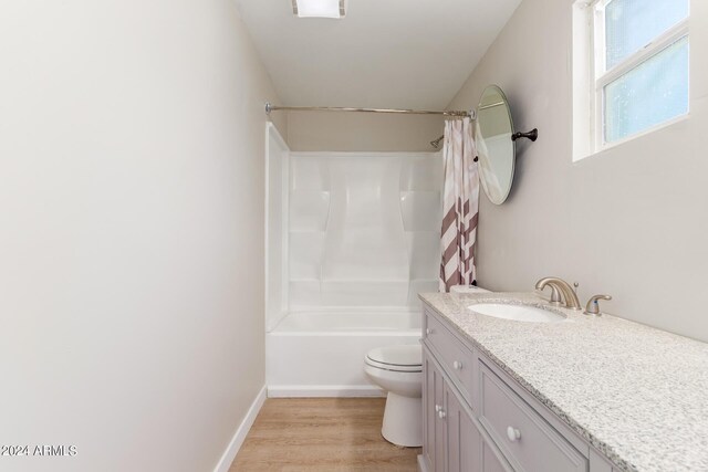 full bathroom featuring toilet, hardwood / wood-style flooring, shower / bath combo, and vanity