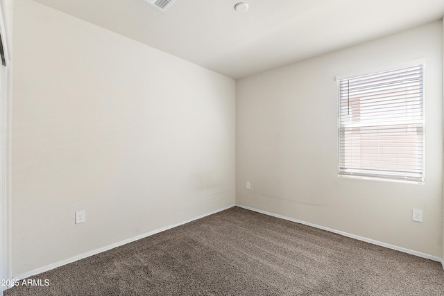empty room featuring carpet floors and baseboards