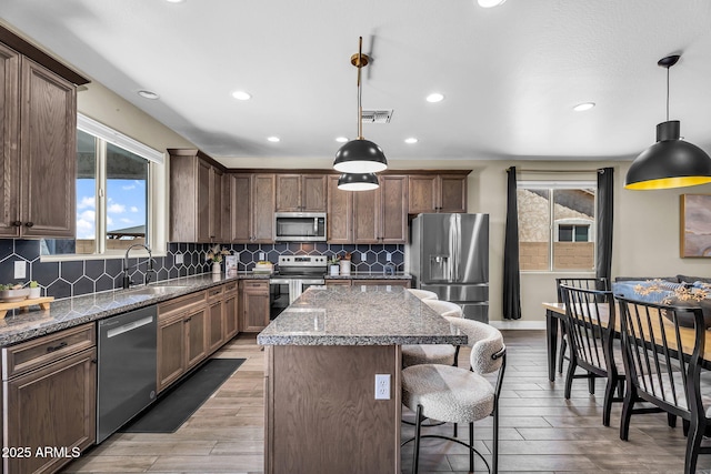 27550 N Silverleaf Rd, San Tan Valley, AZ 85143 - kitchen featuring stainless steel appliances, a sink, recessed lighting, a kitchen island, and a breakfast bar