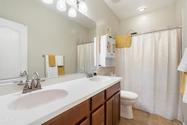 bathroom with double vanity, tile patterned flooring, a sink, and toilet