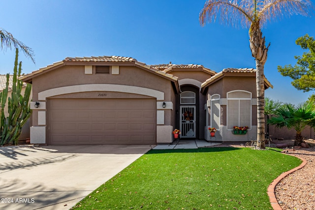 mediterranean / spanish house with a front lawn and a garage