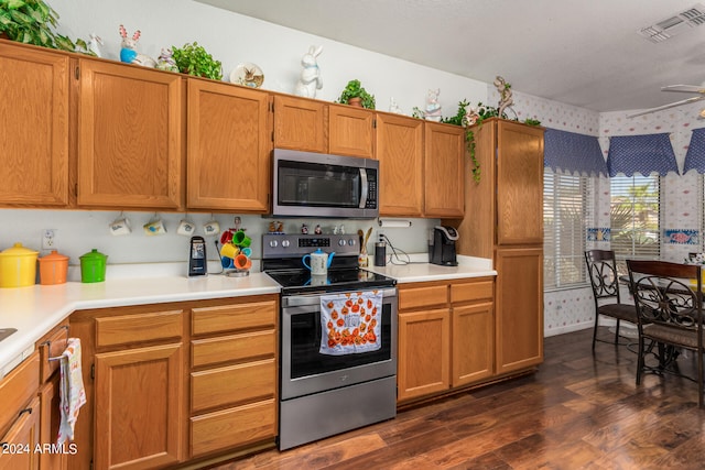 kitchen featuring ceiling fan, stainless steel appliances, and dark wood-type flooring