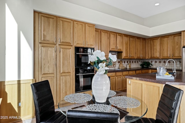 kitchen with tasteful backsplash, double oven, and sink