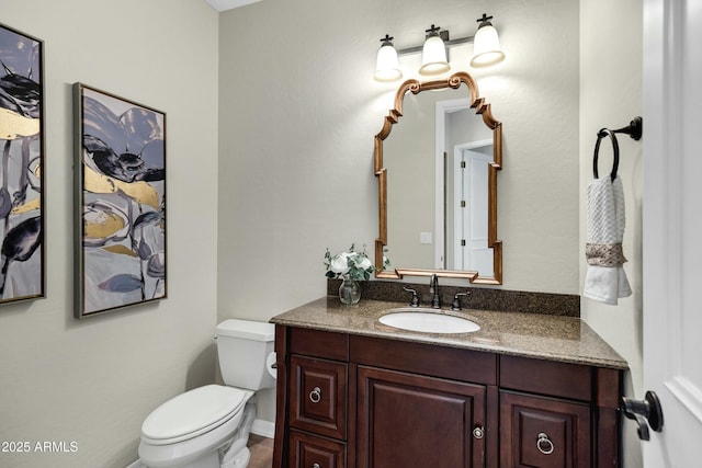 bathroom featuring vanity and toilet