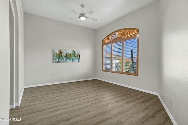 empty room with dark hardwood / wood-style floors and ceiling fan