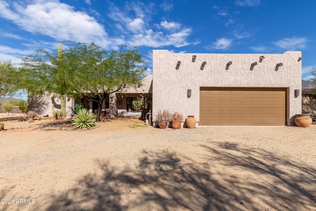 pueblo-style home featuring a garage